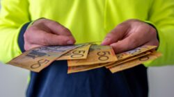 Worker holding Australian cash. | Newsreel