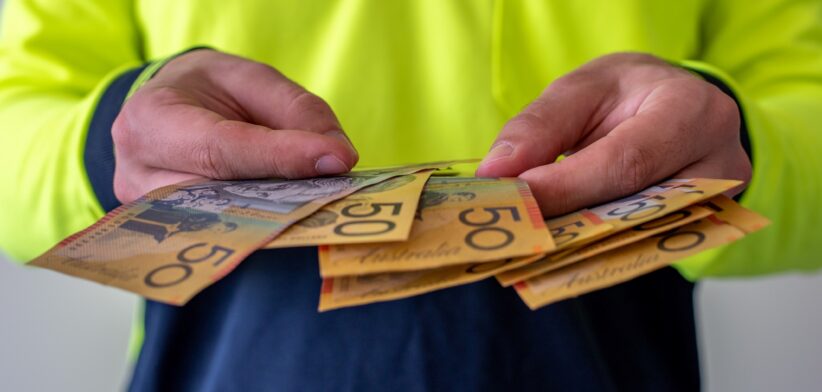 Worker holding Australian cash. | Newsreel