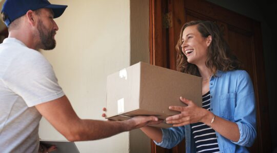 Woman receiving parcel delivery. | Newsreel