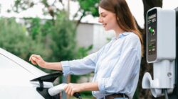 Woman charging electric vehicle. | Newsreel