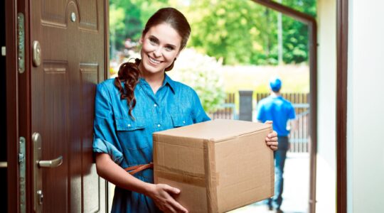 Woman after receiving a parcel delivery. | Newsreel