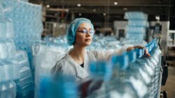 Woman on plastic bottle production line. | Newsreel