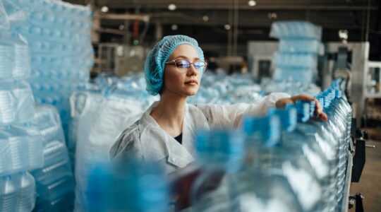 Woman on plastic bottle production line. | Newsreel