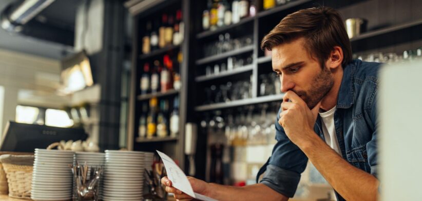 Business owner looking at bills. | Newsreel