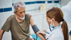 Elderly man being seen by a doctor. | Newsreel