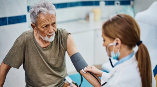 Elderly man being seen by a doctor. | Newsreel