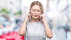 Woman blocking ears from noise. | Newsreel