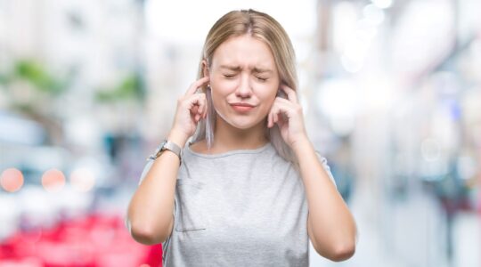 Woman blocking ears from noise. | Newsreel