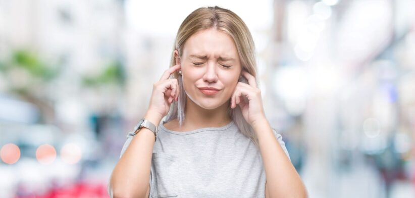 Woman blocking ears from noise. | Newsreel