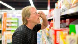 Man looking at supermarket prices. | Newsreel