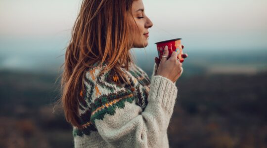 Woman in jumper with hot drink. | Newsreel