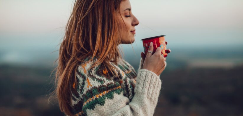 Woman in jumper with hot drink. | Newsreel