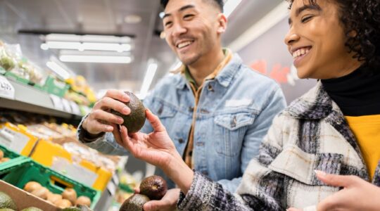 Couple looking at avocados in supermarket. | Newsreel