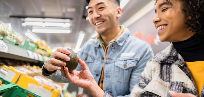 Couple looking at avocados in supermarket. | Newsreel