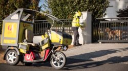 Australia Post postie delivering with dog safely contained.