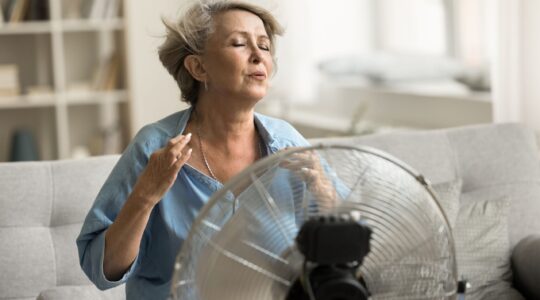 Woman using an electric fan. | Newsreel