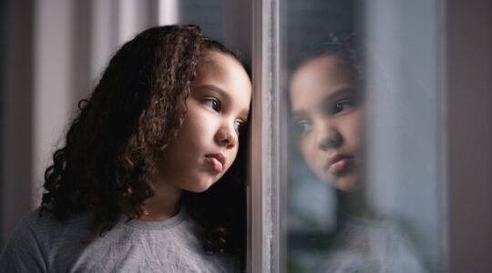 Sad girl looking out window. | Newsreel