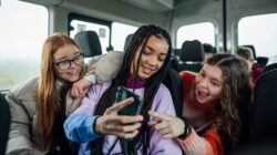 Teenagers looking at mobile phone. | Newsreel