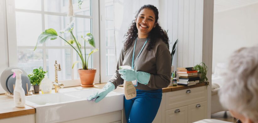 Woman helping older person with cleaning. | Newsreel