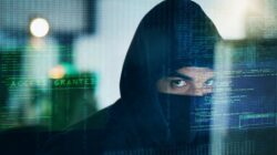 Hooded man in cyber attack graphic. | Newsreel