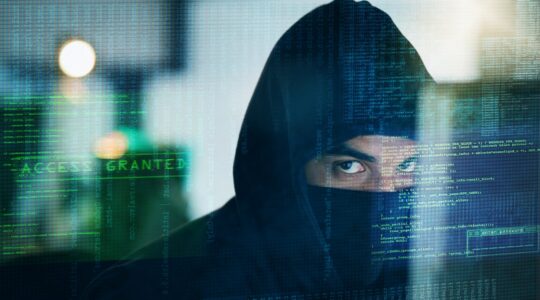 Hooded man in cyber attack graphic. | Newsreel