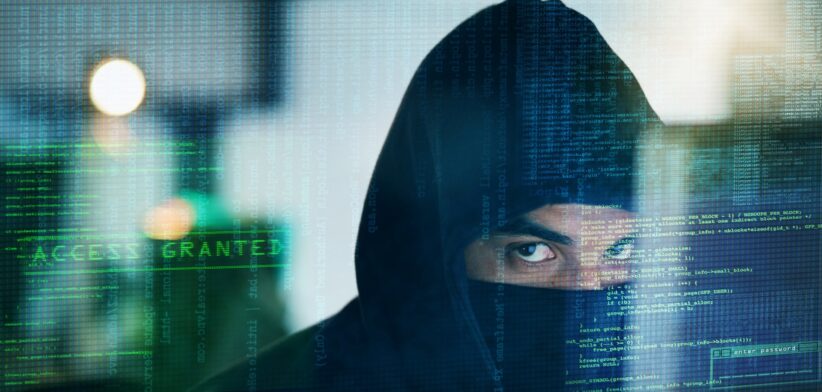 Hooded man in cyber attack graphic. | Newsreel