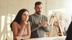 Couple talking to home builder. | Newsreel