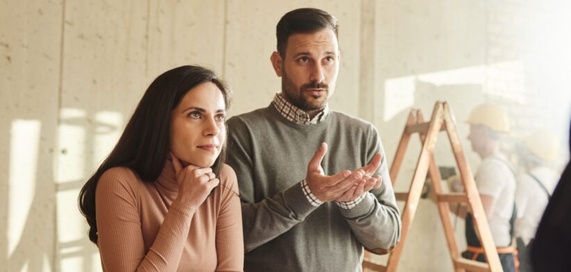 Couple talking to home builder. | Newsreel