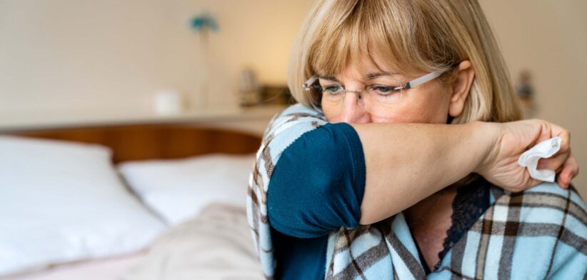 Woman coughing into arm. | Newsreel