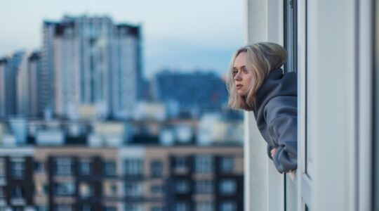 Young person looking our window of apartment. | Newsreel