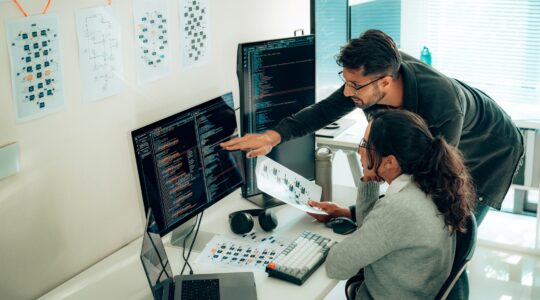 People looking at a computer program. | Newsreel