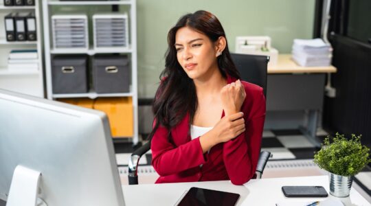 Woman with sore wrist at work. | Newsreel