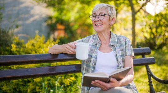 Elderly woman with book and coffee. | Newsreel