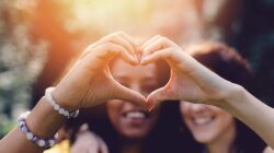 Women making heart shape with hands. | Newsreel