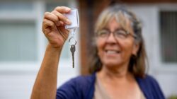 Woman holding key to home. | Newsreel