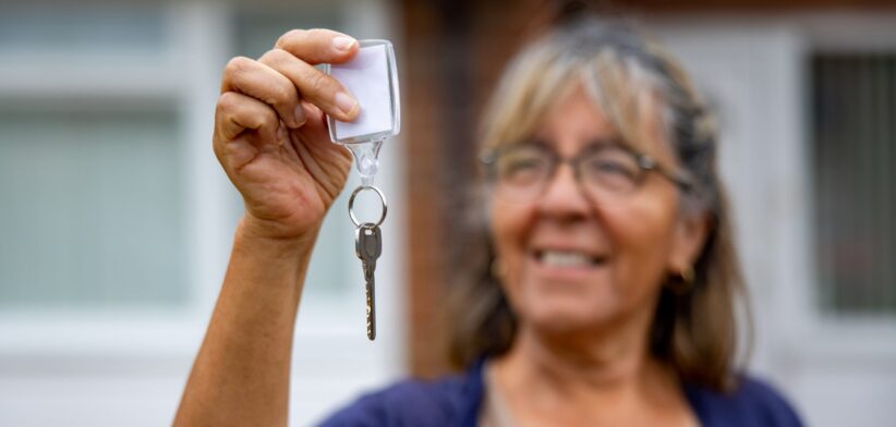 Woman holding key to home. | Newsreel