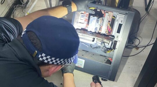 Police officer looks at computer. | Newsreel
