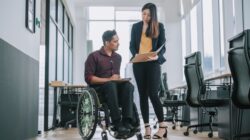 Disabled employee and colleague. | Newsreel