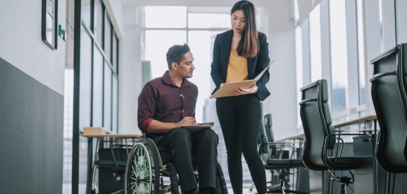 Disabled employee and colleague. | Newsreel