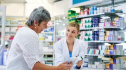 Pharmacist with customer at chemist. | Newsreel