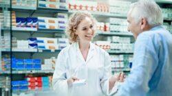 Chemist with elderly customer. | Newsreel