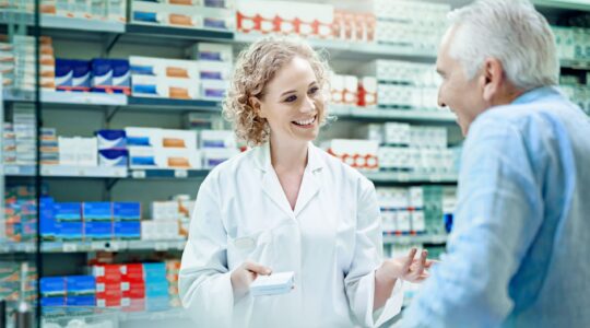 Chemist with elderly customer. | Newsreel