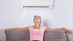 Woman under air conditioner. | Newsreel