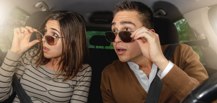 Caucasian couple looking surpsised in the car