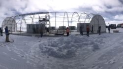 Australian Antarctic Program scientists prepare to pull the cover over the million year ice core drilling shelter. | Newsreel