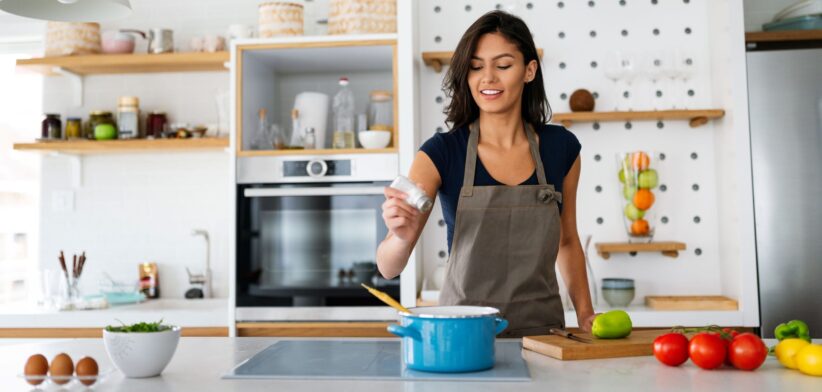 Woman adding salt to food. | Newsreel