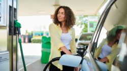 Woman filling up car with petrol. | Newsreel