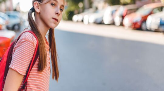 Young girl looking to cross road. | Newsreel