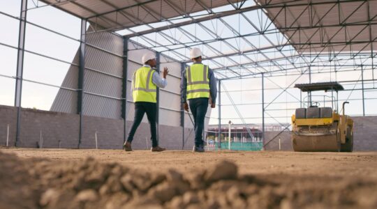 Builders looking at warehouse construction. | Newsreel