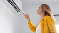 Woman in front of air conditioner. | Newsreel